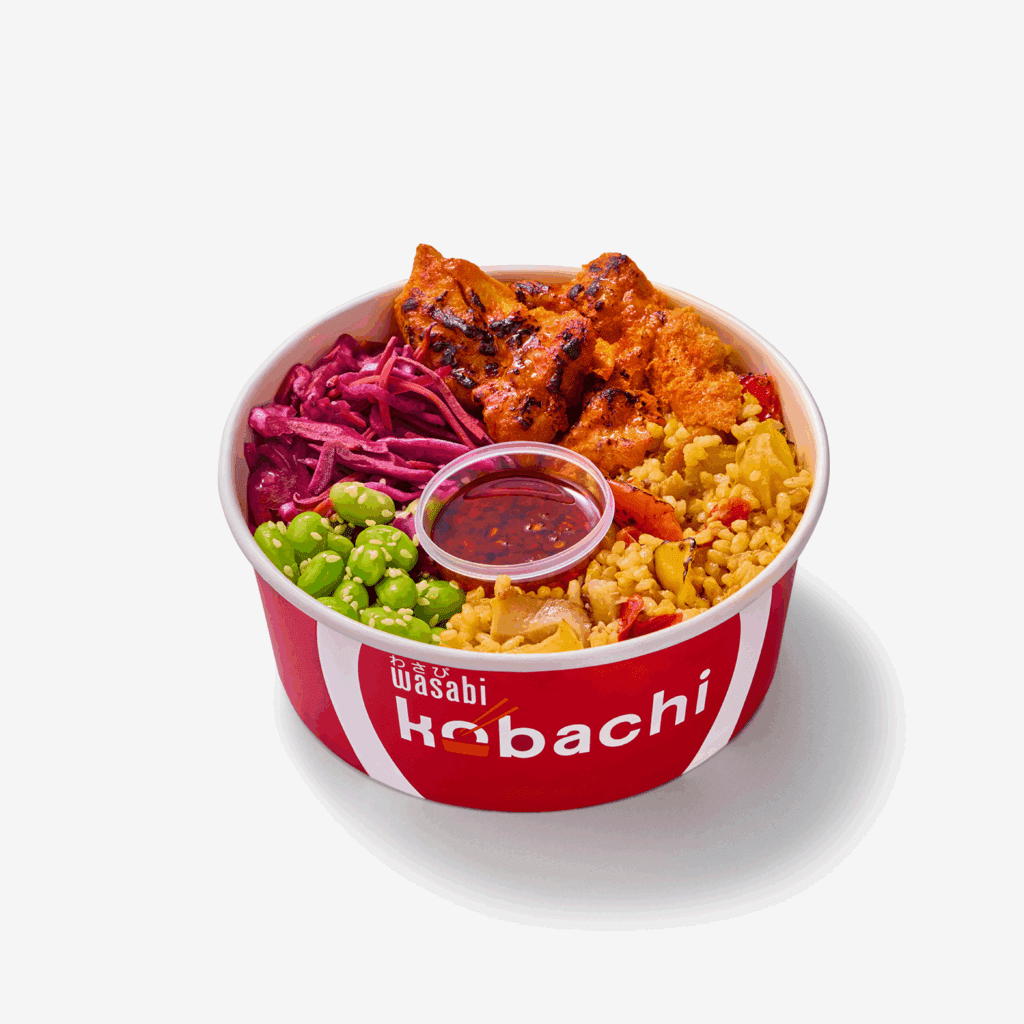A red and white Wasabi Habachi bowl filled with grilled chicken, yellow rice, edamame, pickled red cabbage, and a small container of sauce on top, isolated on a white background.