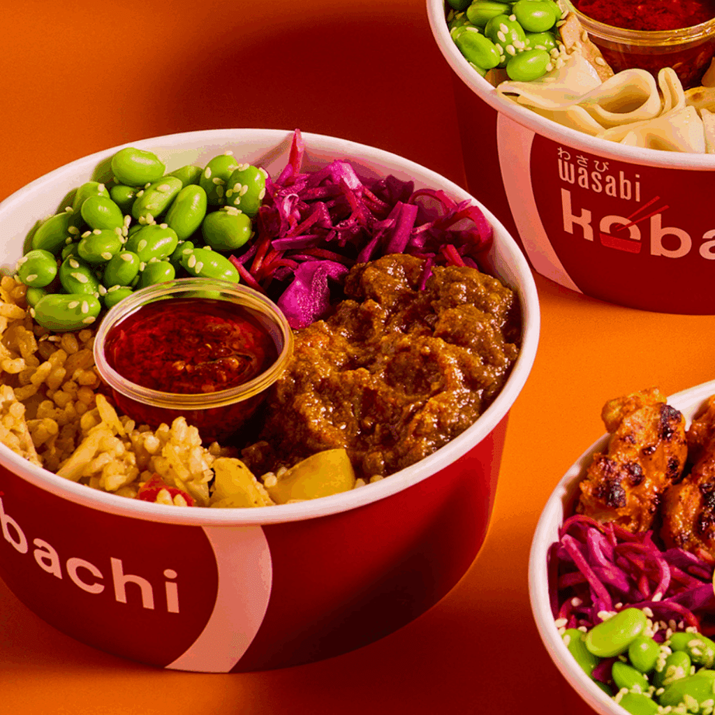 Three colorful bowls of Asian-inspired food on an orange background, each containing rice, edamame, pickled cabbage, sauce, and meat, served in red bowls labeled